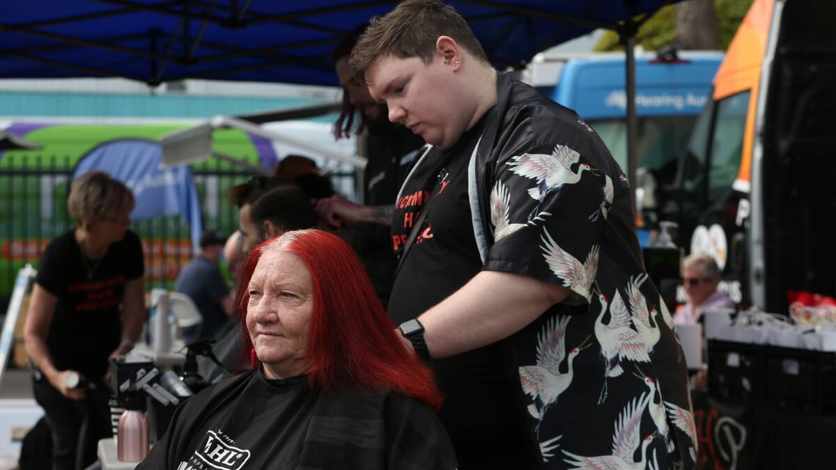 Lindi of Newcastle getting a trim by Troy Meaney of the Community Hair Project at last year's event. Picture by Simone De Peak