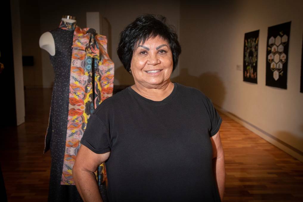 Gomeroi designer Colleen Tighe-Johnson stands next to her designs at the Tamworth regional gallery. Picture by Peter Hardin