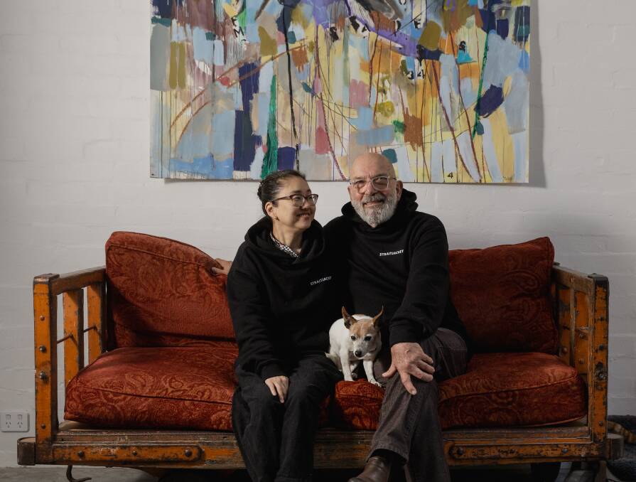 Ahn Wells and Dino Consalvo in their gallery, Straitjacket, with their dog Odea. Jill Orr artwork on the wall. Picture by Marina Neil