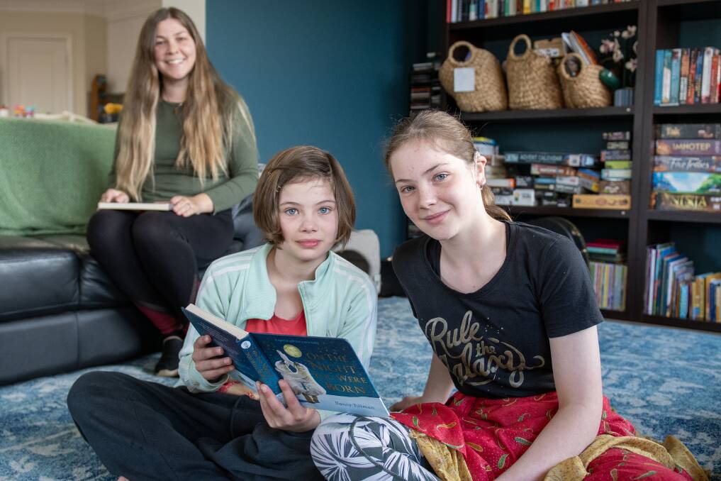 Teacher of the deaf Emily Gray with her students Verity and Evelyn Jones who are sitting holding books. Picture by Belinda Soole 