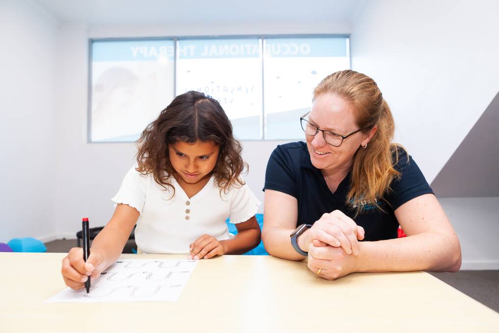 Alyce Svensk helping a child in her occupational therapy clinic before it closed due to rising costs, staff shortages and an NDIS price cap. Picture supplied 