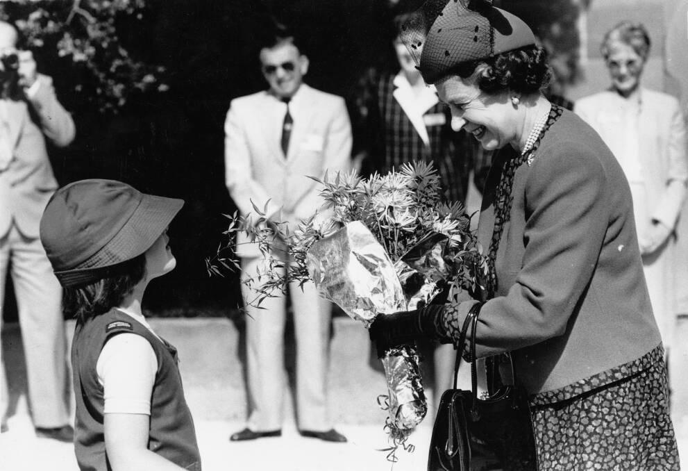 Kotara girl guide Paula Healey presents the Queen with a posy at Customs House. Picture by Ken Robson