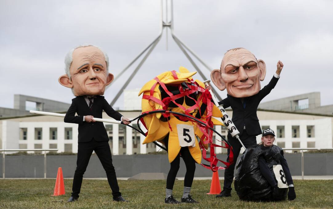 AGITPROP: With debate proceeding about the National Energy Guarantee, caricatures of Malcolm Turnbull and Tony Abbott capture a solar power symbol outside Parliament House in Canberra this week. Picture: Alex Ettinghausen
