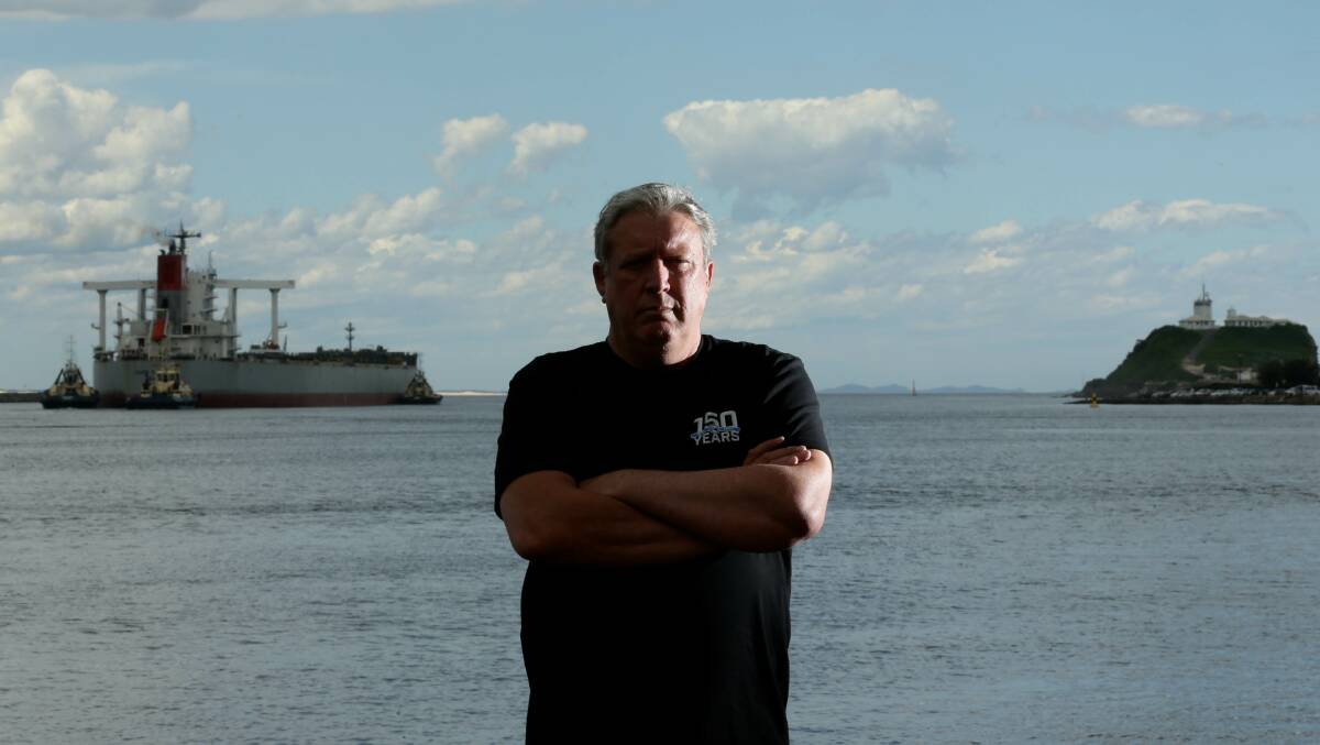 Maritime Union of Australia Newcastle branch secretary Glen Williams yesterday, with Svitzer tugs escorting the coal ship Cape Rainbow out of the port and on its way to Japan. Picture by Jonathan Carroll