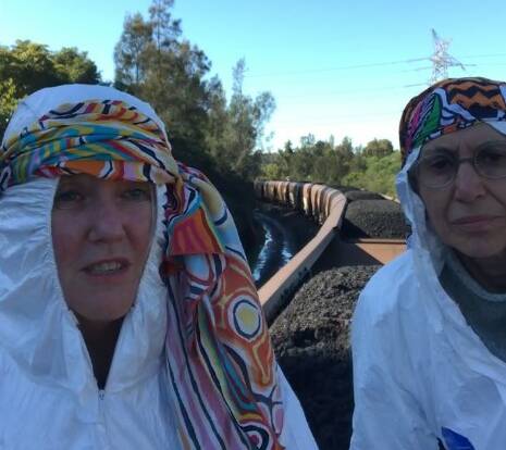 Activists, believed to be two women called Cat and Rosie, have climbed on top of a coal train. Picture is a screenshot from a Blockade Australia live video