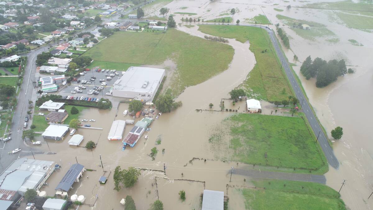 An aerial view overlooking the flood waters flowing behind Woolworths and into Greg Forbes Automotive. Drone photo by Troy Higgins.