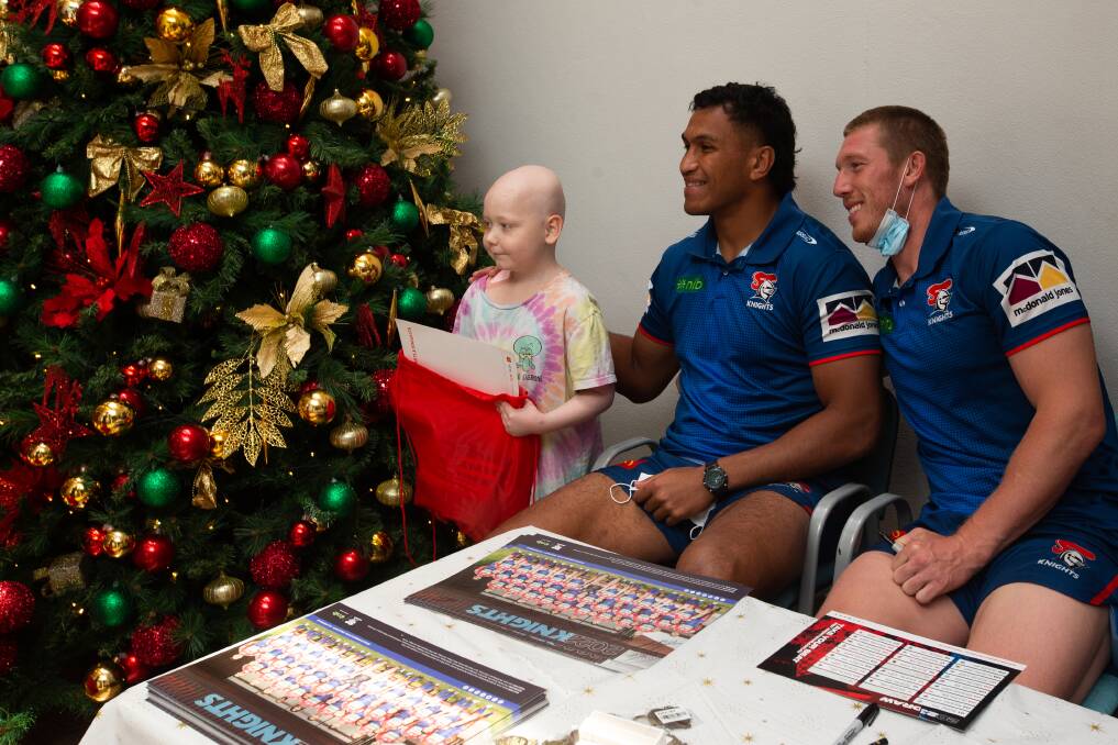 Jack Hetherington and Jacob Saifiti with young fan Riley Garland during the Knights' visit to John Hunter Hospital this week. Picture by Jonathan Carroll
