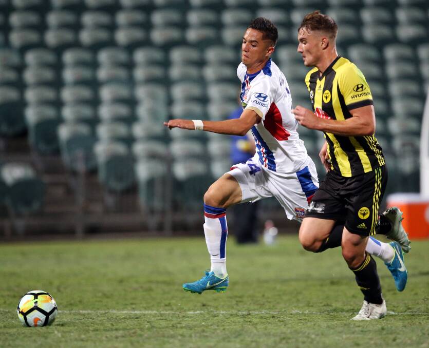 ON THE BALL: Joe Champness competes with Wellington defender Dylan Fox for possession in the Jets 1-0 win on Saturday night. Picture: AAP