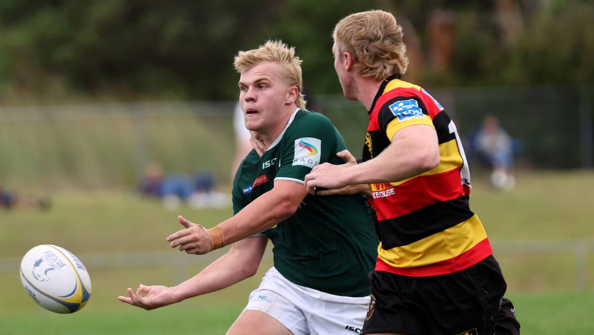 Jordan Baggs offloads a pass for Merewether during the Mick 'Whale' Curry Memorial Sevens. Picture by Marina Neil