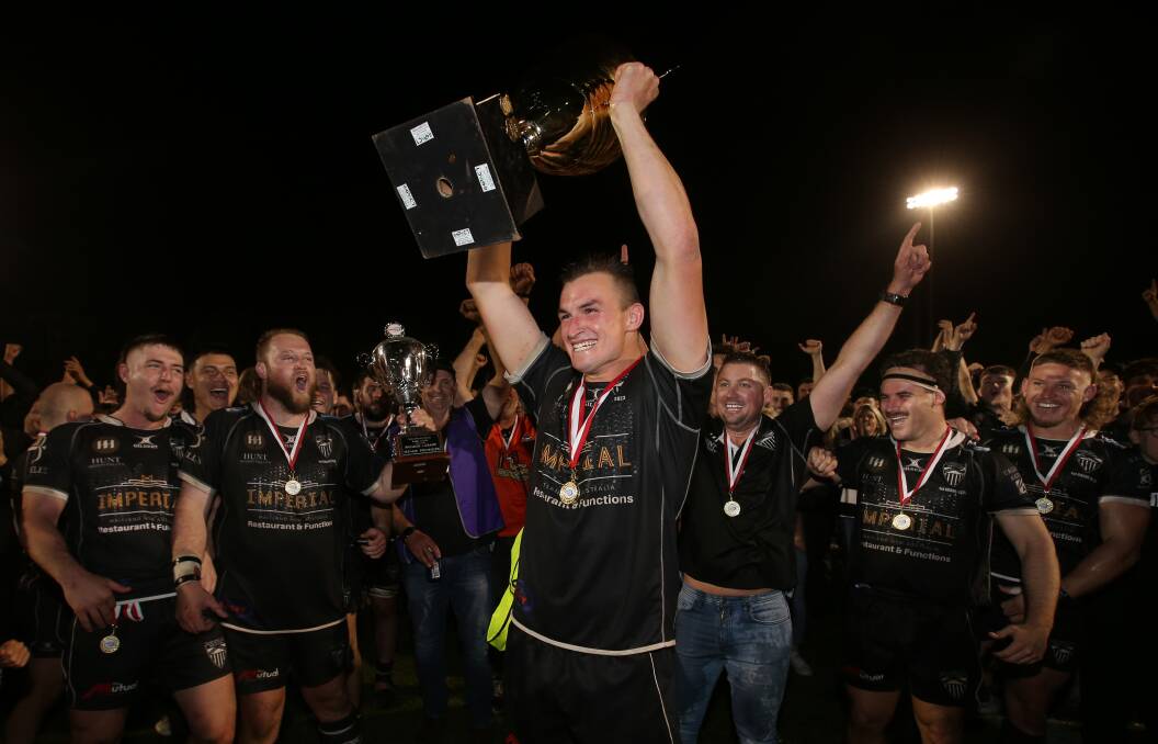 Inspirational Maitland captain Sam Callow hoists the premiership cup high after the Blacks grand-final win over Merewether. Picture by Simone De Peak