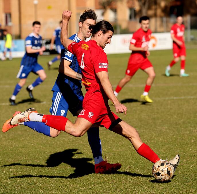 Olympic's Jason Hoffman puts pressure on Broadmeadow's Tom Beecham on Sunday. Picture by Peter Lorimer