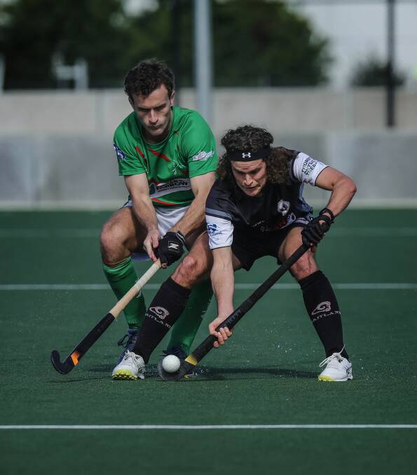 Wests' Angus Oakford and Maitland player Ryan Lance battle it out on Sunday at Newcastle International Hockey Centre. Picture by Marina Neil