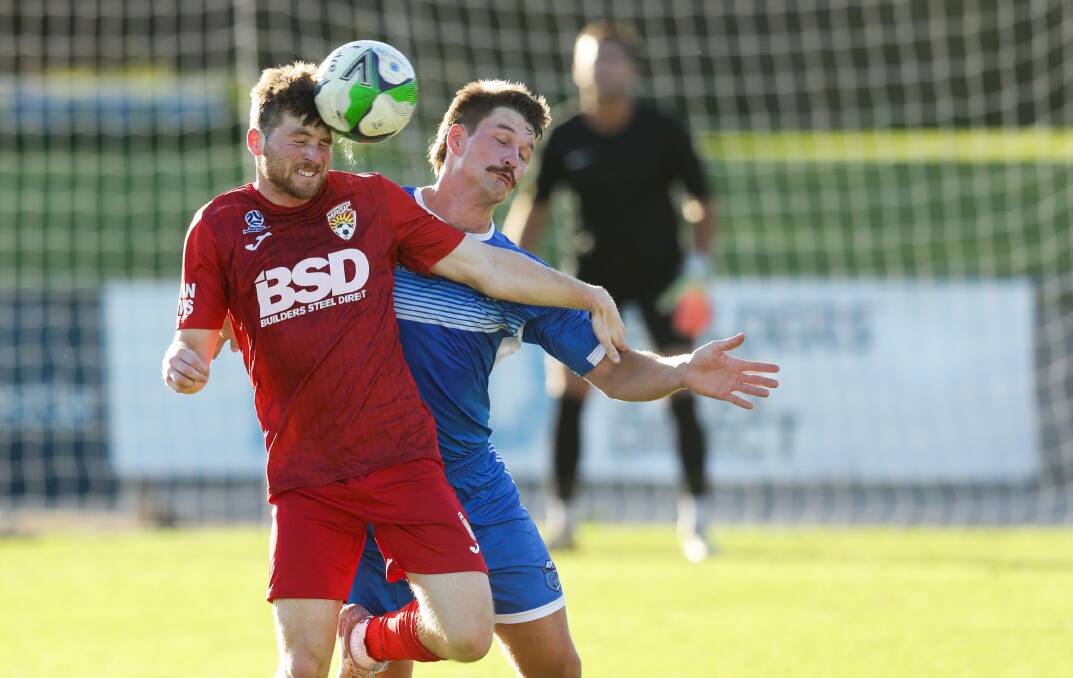 Hat-trick scorer Riley Smith, left, battles with Bangalow's Connor Bensley in Broadmeadow's Australia Cup win at Magic Park on Saturday. Picture by Jonathan Carroll