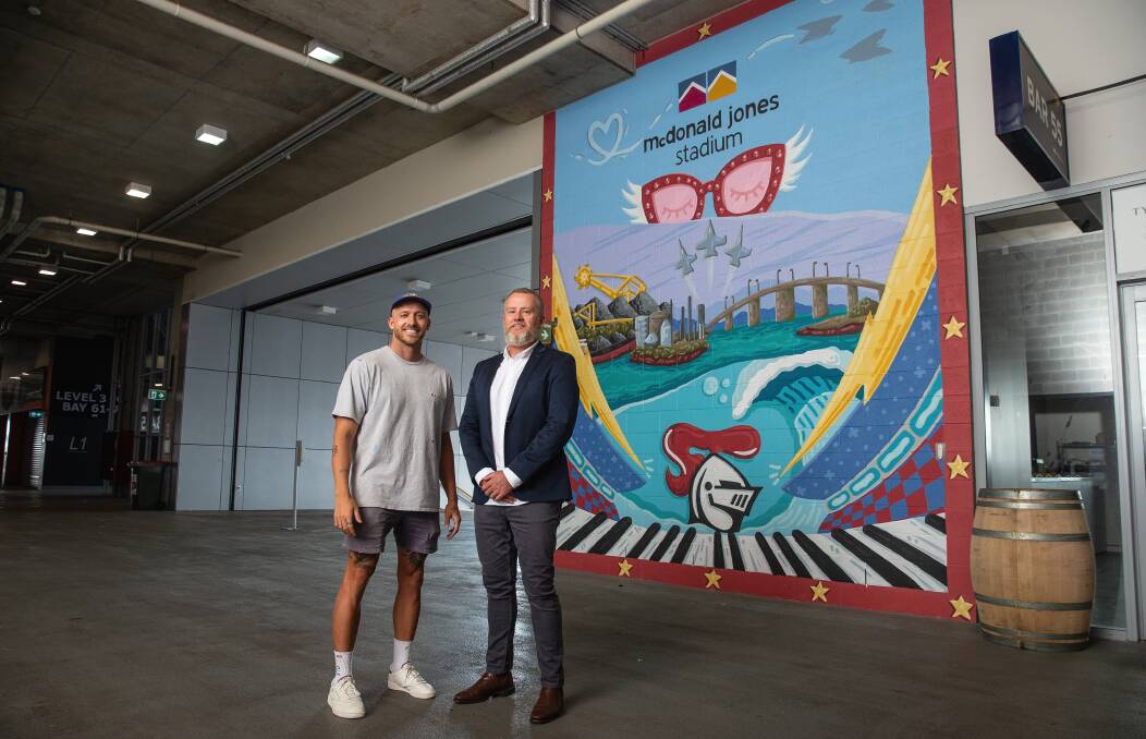 Newcastle artist Mitch Revs and venues manager Dean Mantle in front of Revs' mural designed for Elton John's concerts. Picture by Marina Neil