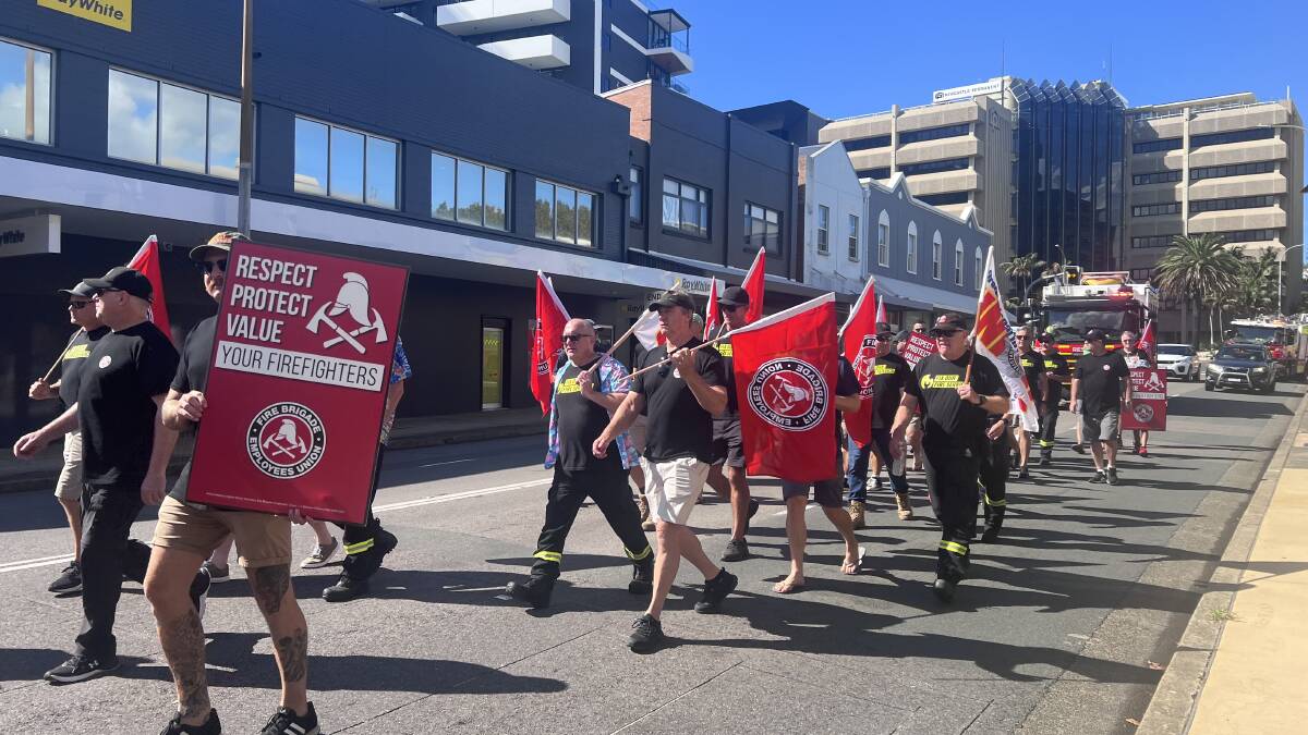 Firefighting union members march towards Tim Crakanthorp's office.
