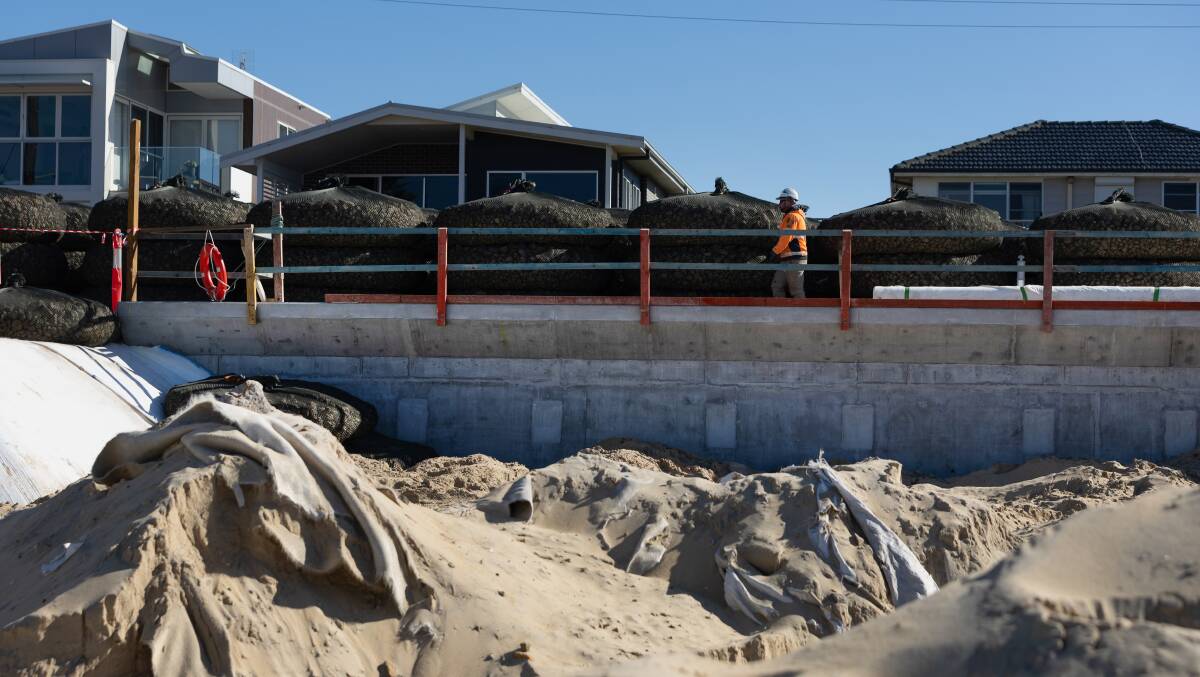 Works ongoing on Stockton Beach to install a 50 metre rock bag wall. Picture by Marina Neil