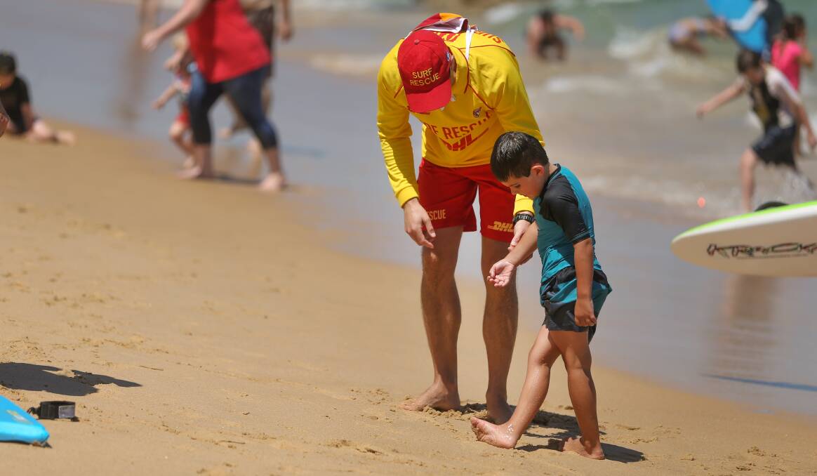 ARE YOU OK MATE: A Cooks Hill Surf Lifesaving Club volunteer checks in on a young swimmer at Bar Beach on Boxing Day. Picture: Marina Neil