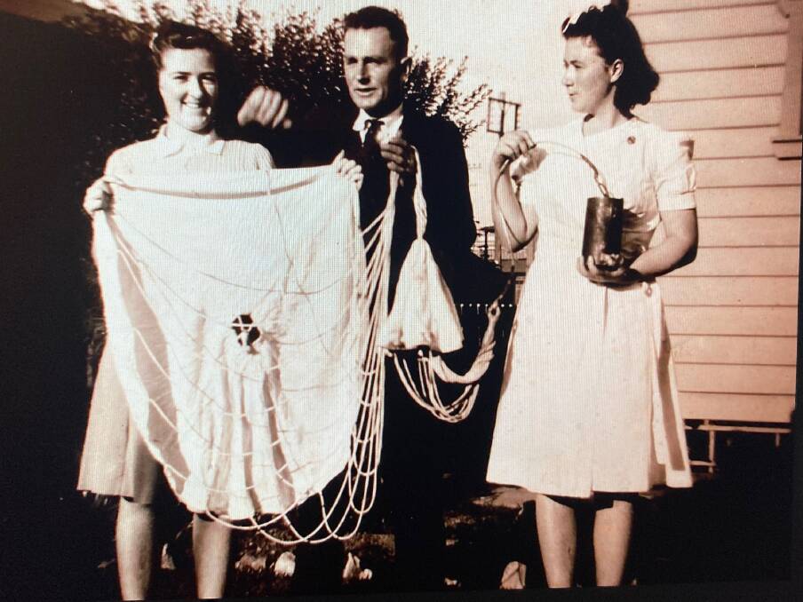 Helen Skene (left) with Norman Pender and Joyce Skene display an enemy star shell canister and silk parachute in 1942. Picture - Helen Marshall
