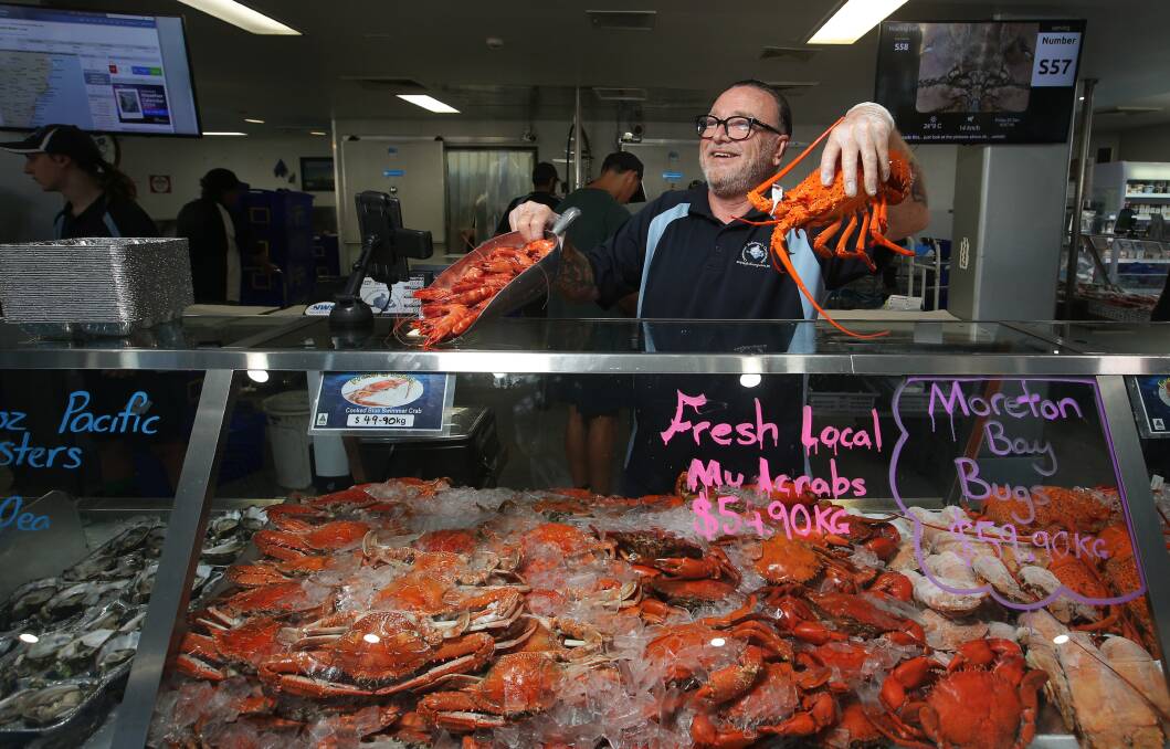 Staff member Dave Boatswain serving customers at Newcastle Fishermen's Co-op on Friday. Picture by Simone De Peak