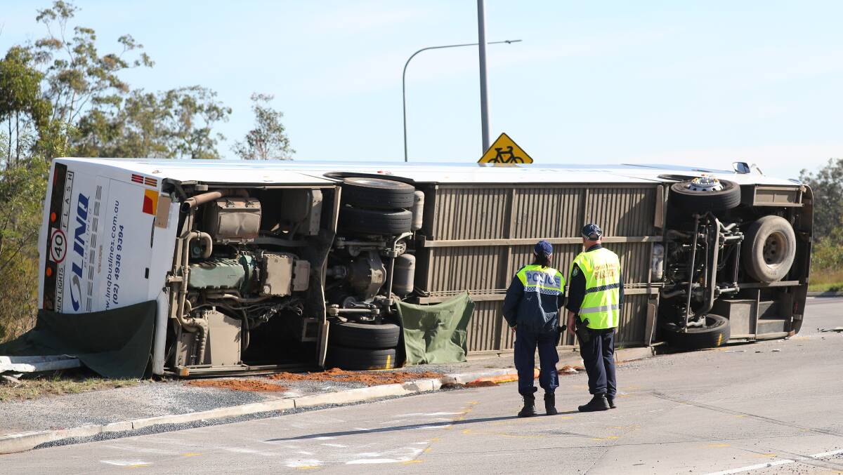 The coach lies on its side beside the roundabout on Wine Country Drive. Picture by Peter Lorimer