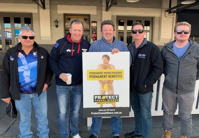 PROTECTION: Northern district mineworkers with a CFMEU poster on the 'permanent casuals' controversy.