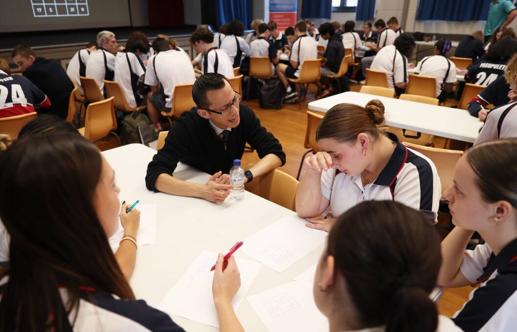 Eddie Woo works with a group of Year 12 students at Newcastle High School on May 15. Picture by Peter Lorimer