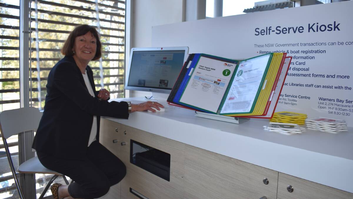 HOW TO: Mayor Kay Fraser tries the self-serve kiosk at Swansea library. Library staff and detailed information at the kiosks make them quick and easy to use. Picture: Supplied