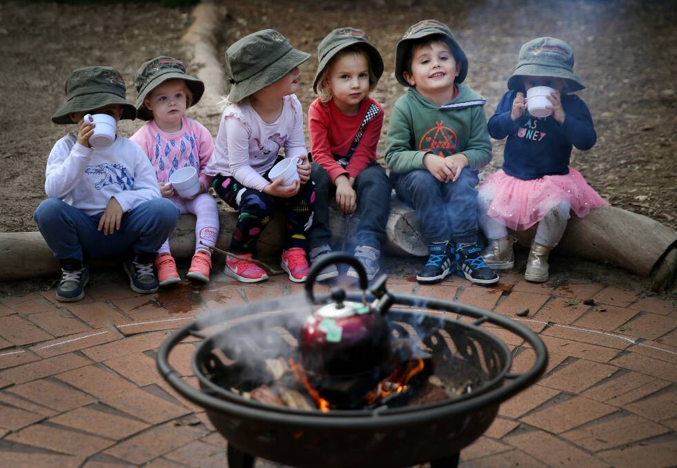 Cosy: Preschoolers Benji, Rose, Eden, Bowie, Theo and Vivienne are learning how to perceive, assess and manage risk, such as open fire. Picture: Marina Neil
