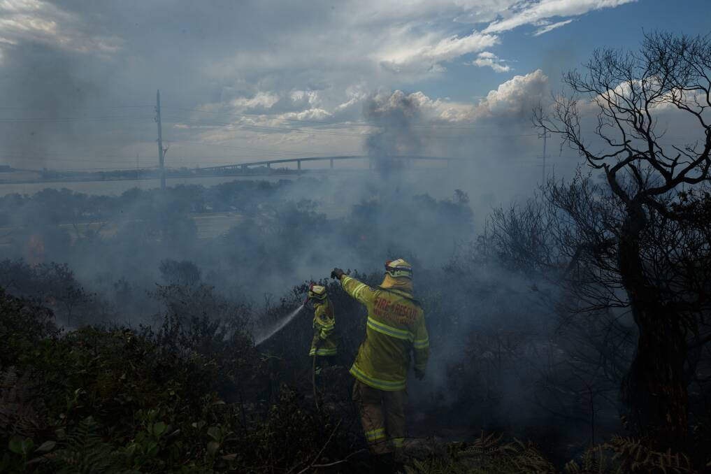 Ominous: Firefighters fought a blaze in the shadow of Stockton bridge that produced a plume visible across the city. Picture: Max Mason-Hubers