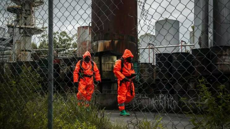 NSW Fire and Rescue officers at the heavily contaminated Truegain, or Australian Waste Oil Refineries, site in Rutherford in 2014.