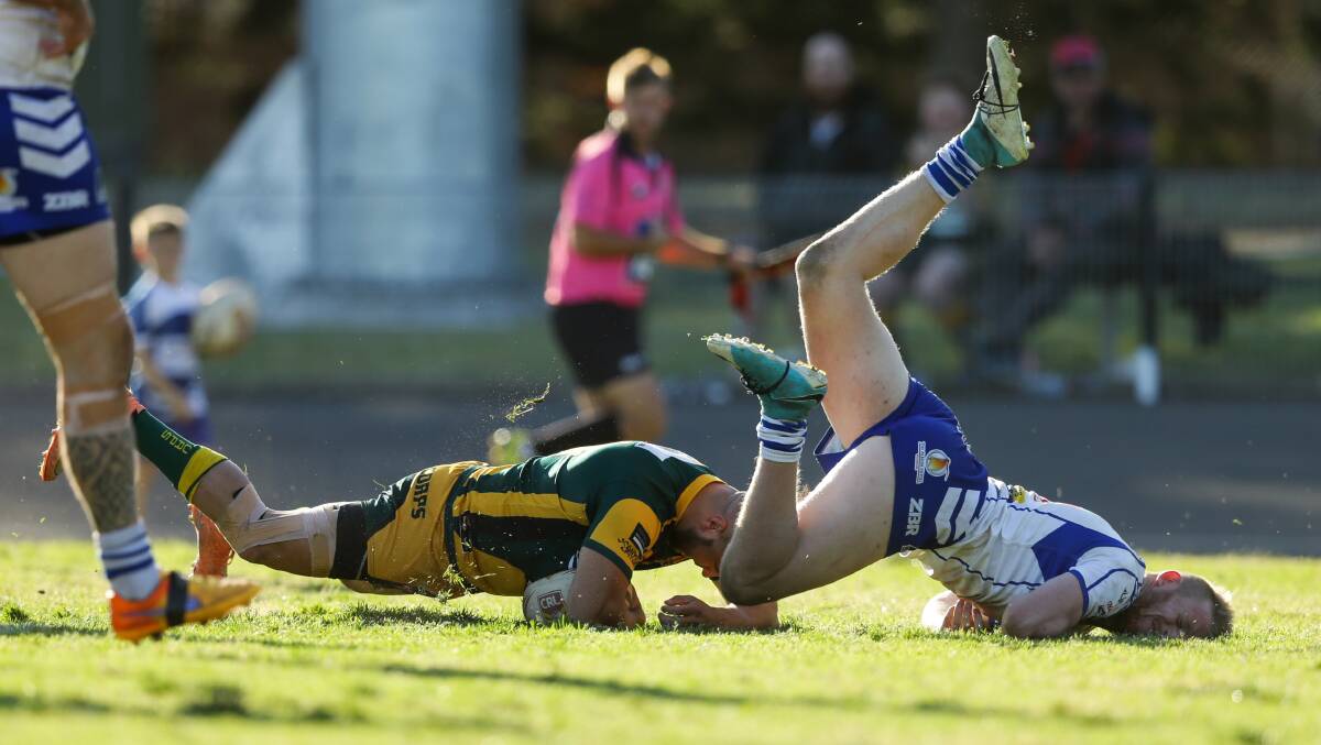 RUNAWAY: Macquarie's Randall Briggs crashes over for one of the Scorpions 11 tries despite the best efforts of Central's Justin Worley. Picture: Jonathan Carroll 