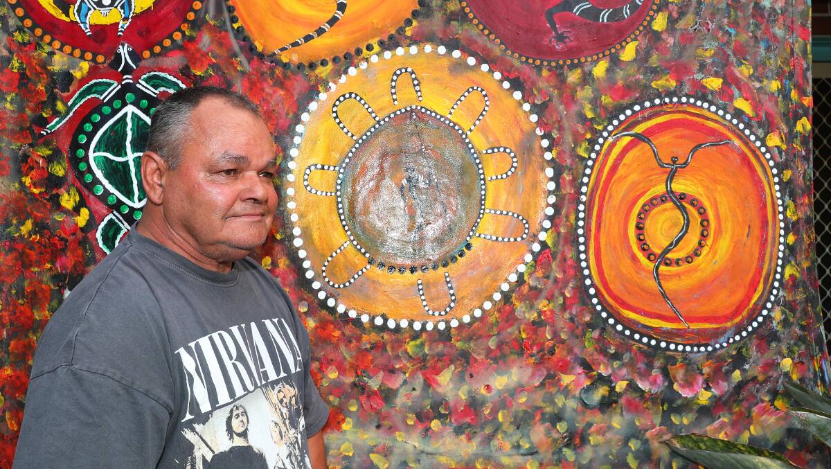 Wiradjuri artist Uncle Billy Lamb in front of a mural at his house in Carrington. Picture by Peter Lorimer 