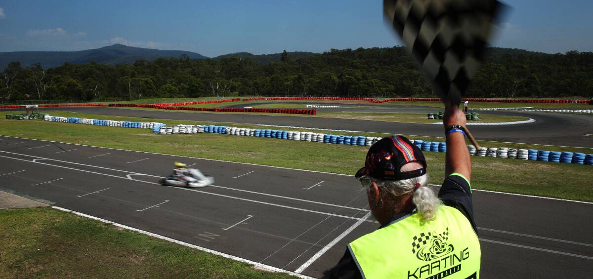 ACTION-PACKED: Peter Kennedy waves the finish flag during practice at Newcastle Kart Racing Club at Cameron Park. Picture: Max Mason-Hubers