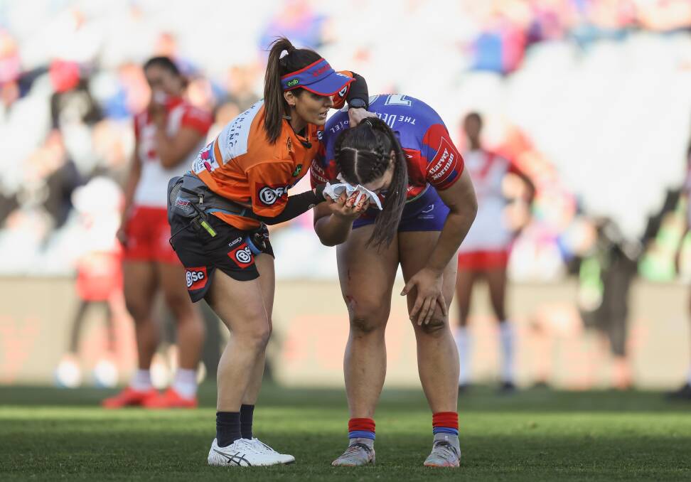 Knights NRLW physio and orange-shirt trainer Bec Swan helps prop Rima Butler at McDonald Jones Stadium last Saturday after a head clash. Picture by Marina Neil