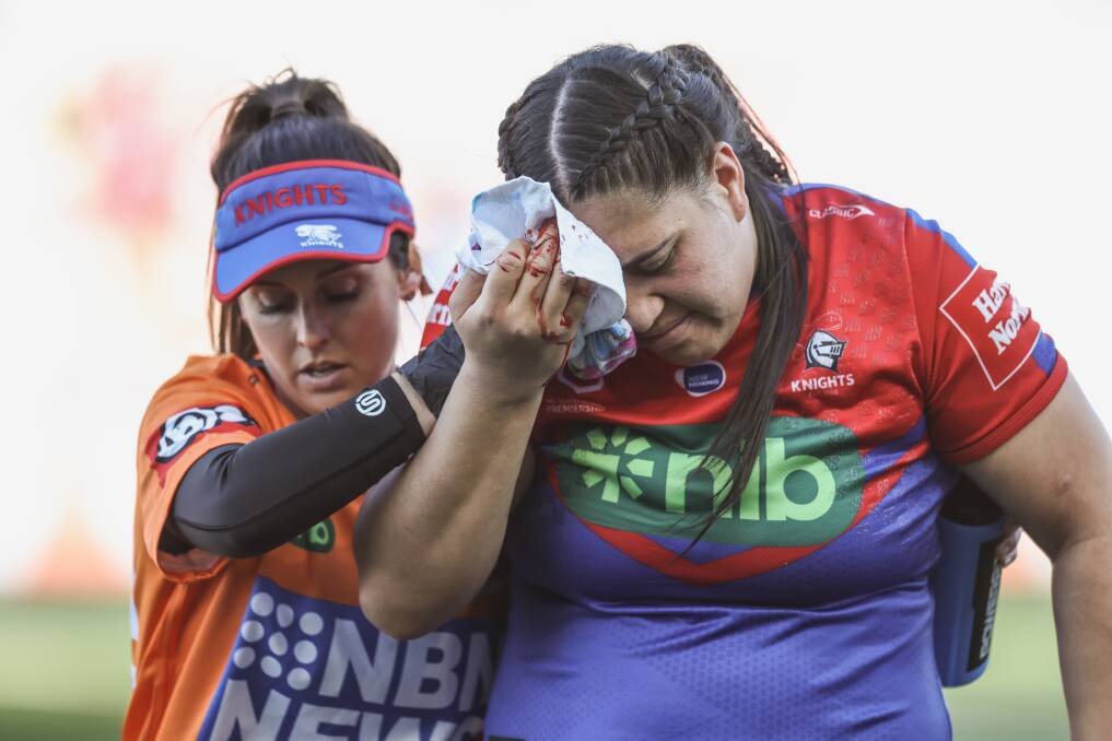 Knights NRLW physio and orange-shirt trainer Bec Swan helps prop Rima Butler from the field at McDonald Jones Stadium last Saturday after a head clash. Picture by Marina Neil