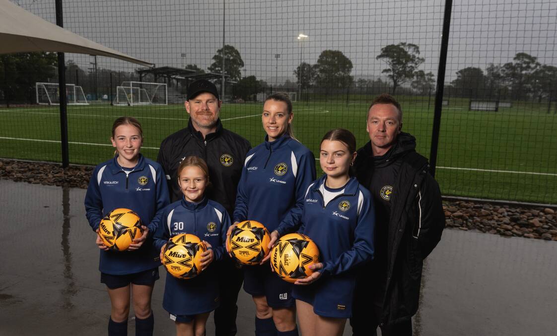 Lake Macquarie president Steve Graham, left at back, with players Winnie Lambess, Cleo Linacre, Rachael Wein, Isabella Caruana and sporting director Adam Linacre. Picture by Marina Neil