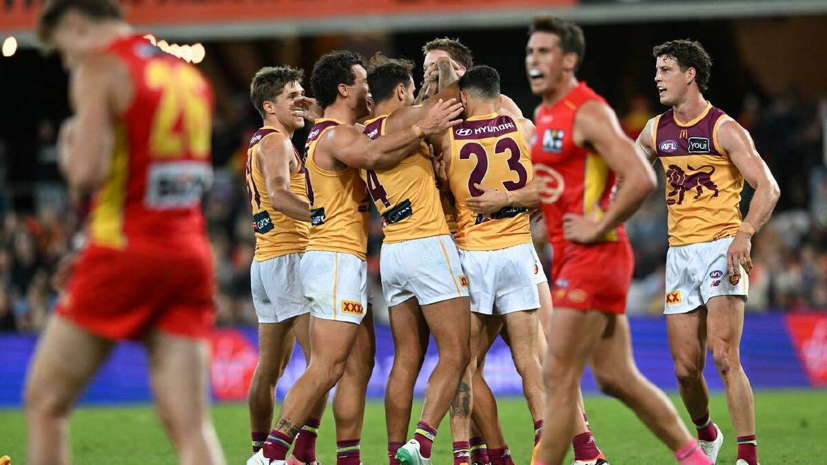 Lions players get around Kai Lohmann after a goal in their QClash win on the Gold Coast. (Darren England/AAP PHOTOS)