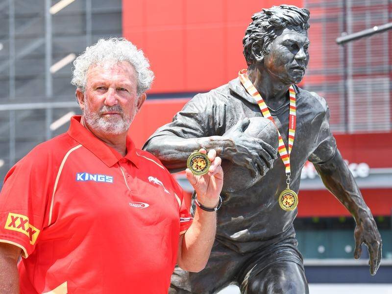 Brad Beetson, son of Arthur Beetson, with his father's statue and the inaugural Artie Legacy Medal. (Jono Searle/AAP PHOTOS)