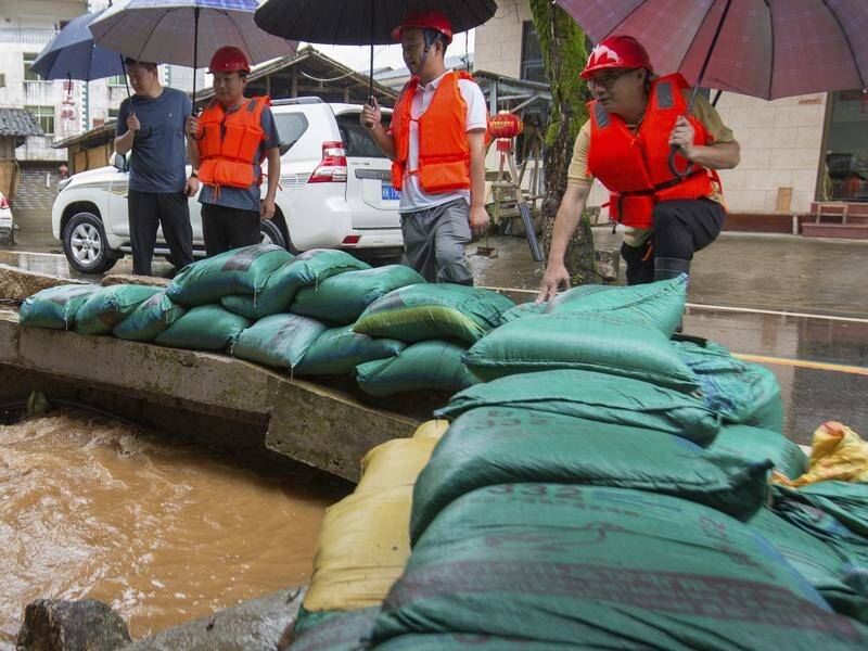 Floodwaters have breached a dam in southern China, sparking mass evacuations in Hunan province. (AP PHOTO)