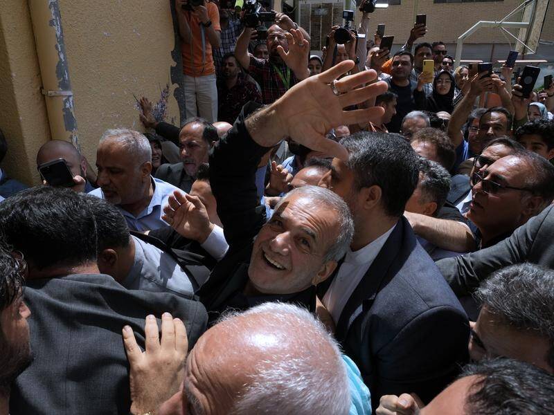Masoud Pezeshkian (centre) has been declared the winner of Iran's presidential election. (AP PHOTO)