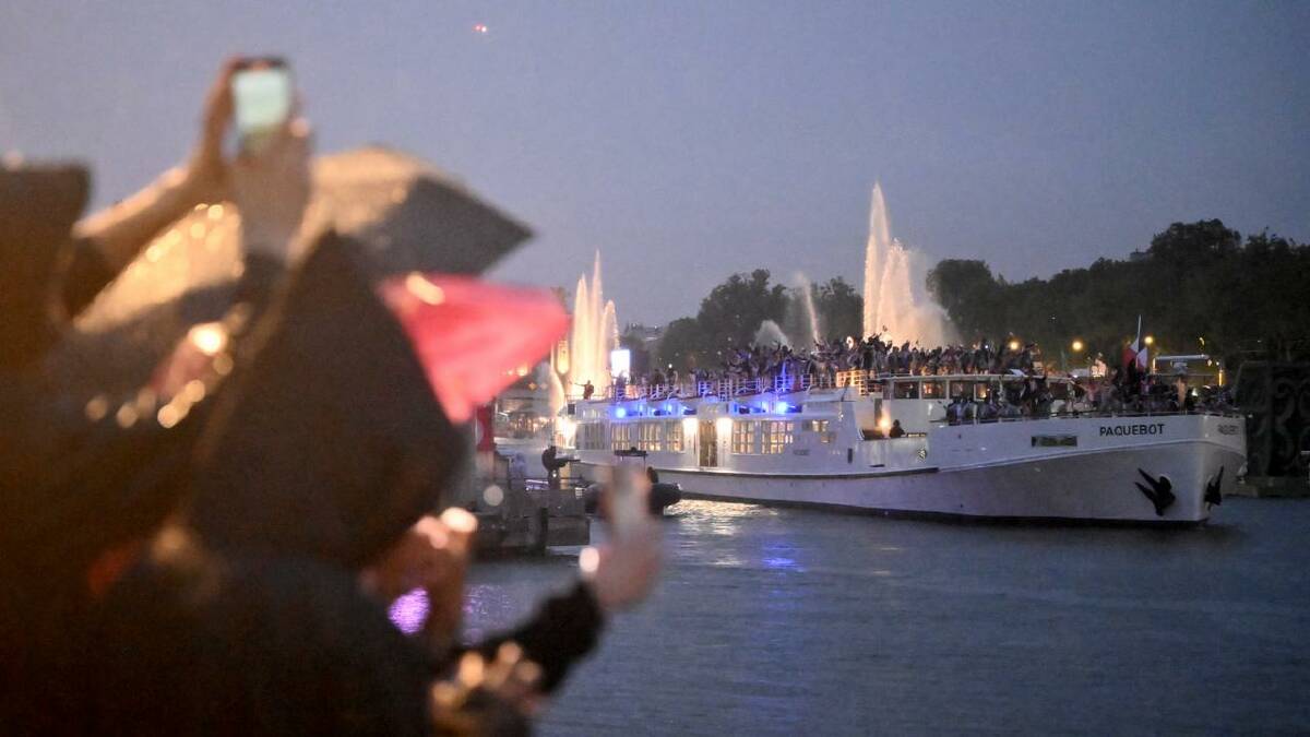 Rain did not deter delegations transported in 85 boats down a crowd-lined River Seine. (Joel Carrett/AAP PHOTOS)