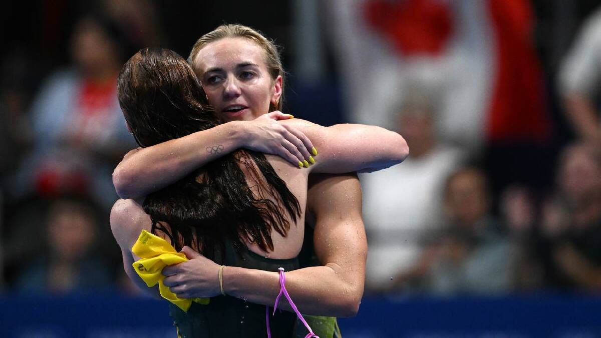 Ariarne Titmus (right) congratulates Mollie O'Callaghan on her gold medal win. (Dean Lewins/AAP PHOTOS)