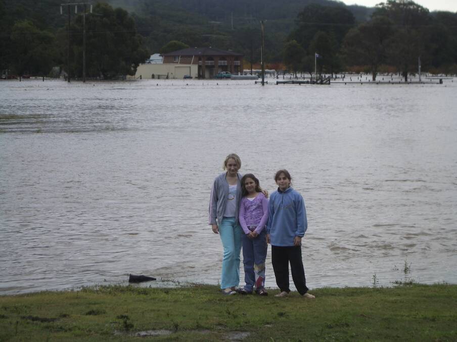 A Kangy Angy resident and her children stand in front of flooded Bolte family paddocks. 