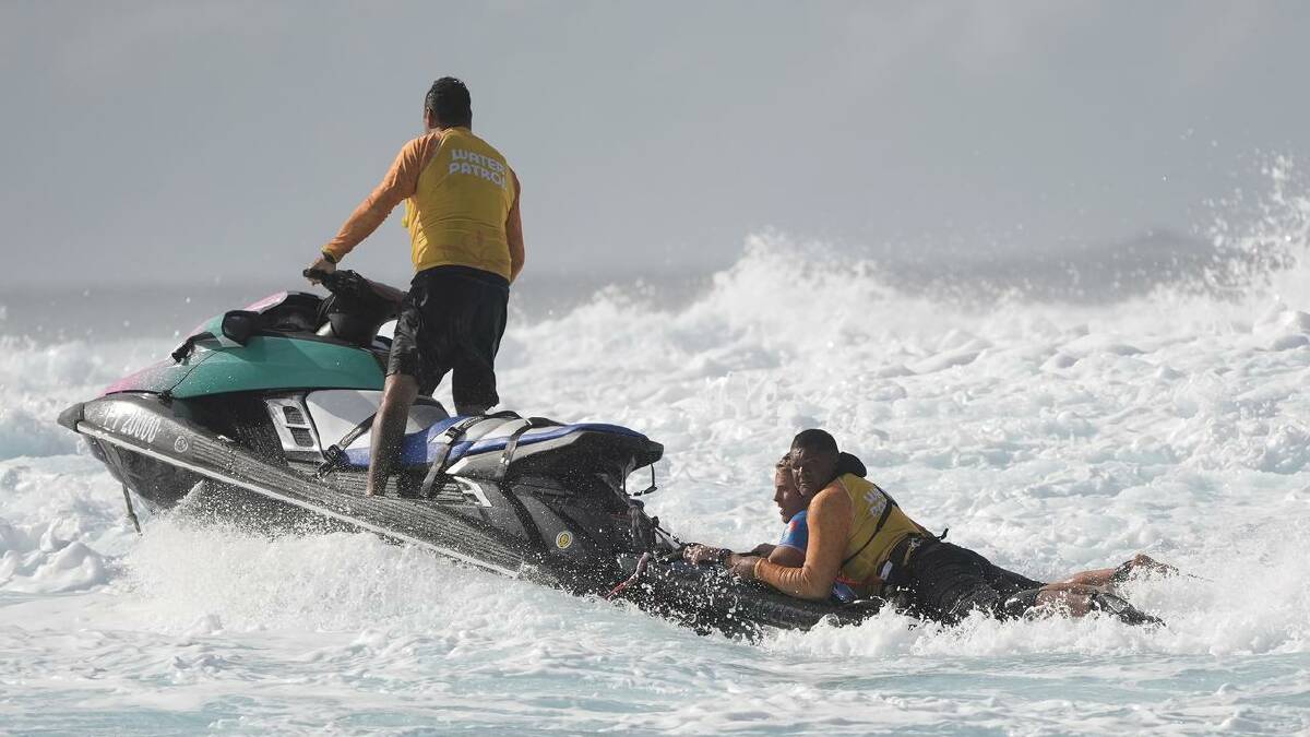 Alan Cleland Quinonez rides on the back of a water patrol jet ski at Teahupo'o after a wipeout. (AP PHOTO)