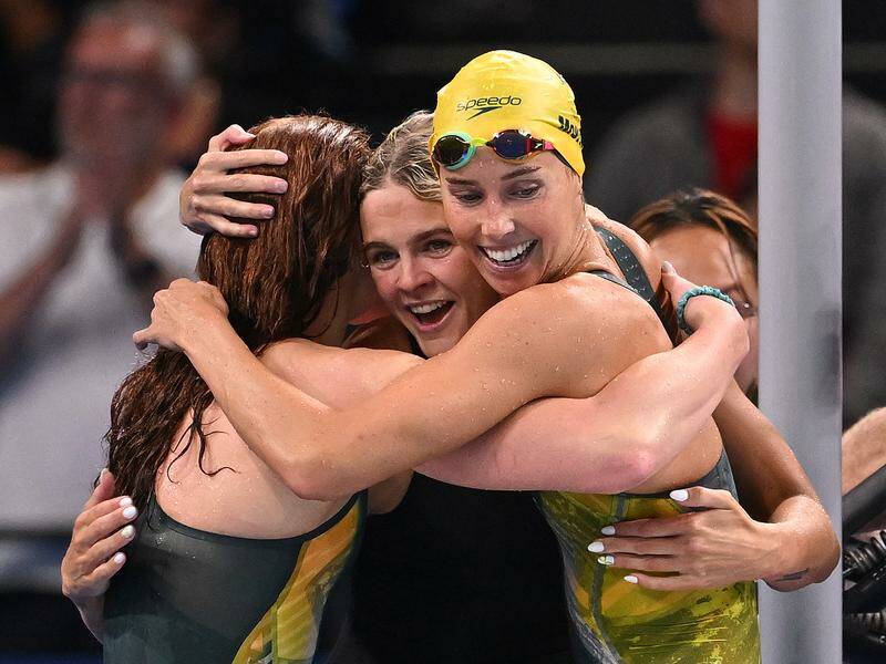 Shayna Jack (centre) is sandwiched by her triumphant women's 4x100m freestyle relay teammates. Photo: Dave Hunt/AAP PHOTOS