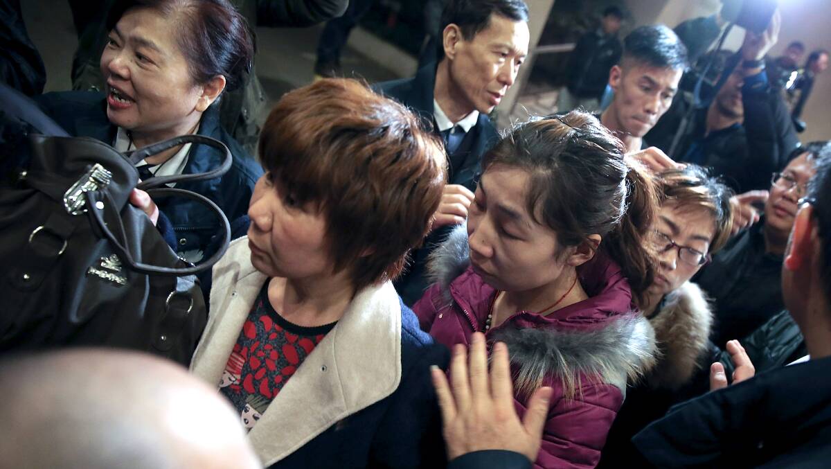 Relatives of passengers onboard Malaysia Airlines flight MH370 leave after applying for their Chinese passports to be ready to travel to the crash site as the search continues for the missing Malaysian airliner on March 9, 2014 in Beijing, China. Photo: Getty Images