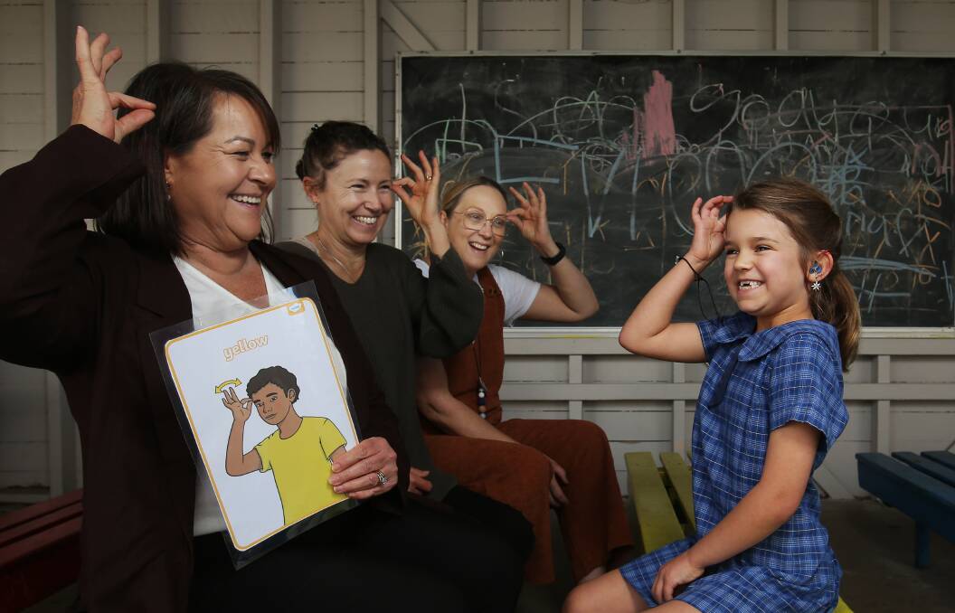 Year 1 Hamilton Public School student Gillian Stewart, 6, signing the yellow colour with Assistant Principal Itinerant Support Teacher Hearing (ISTH) Deb Munro and her year one teachers Naomi Isaacs and Jade Marr. Picture by Simone De Peak