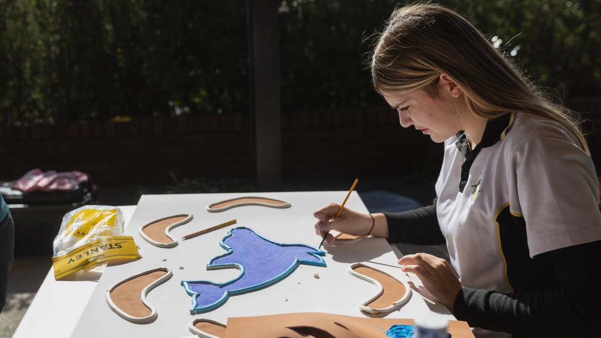 Lily Ryan works on the totem painting. Picture by Marina Neil