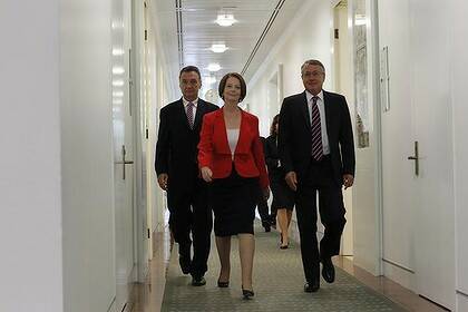 Prime Minister Julia Gillard emerges victorious from the caucus ballot flanked by acting Foreign Minister Craig Emerson (left) and Treasurer Wayne Swan.