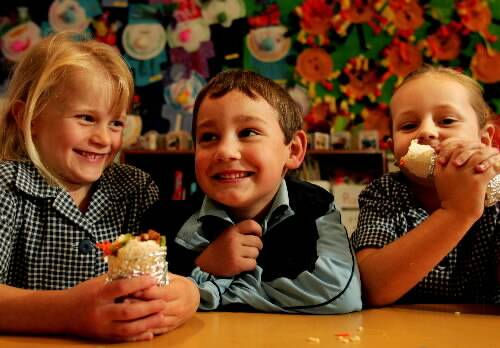 WRAPPED: Rylan Milton watches Katelyn Haugh, left, and Billie Richardson tuck into his ‘Rylan’s wraps’ yesterday. Picture by Simone De Peak